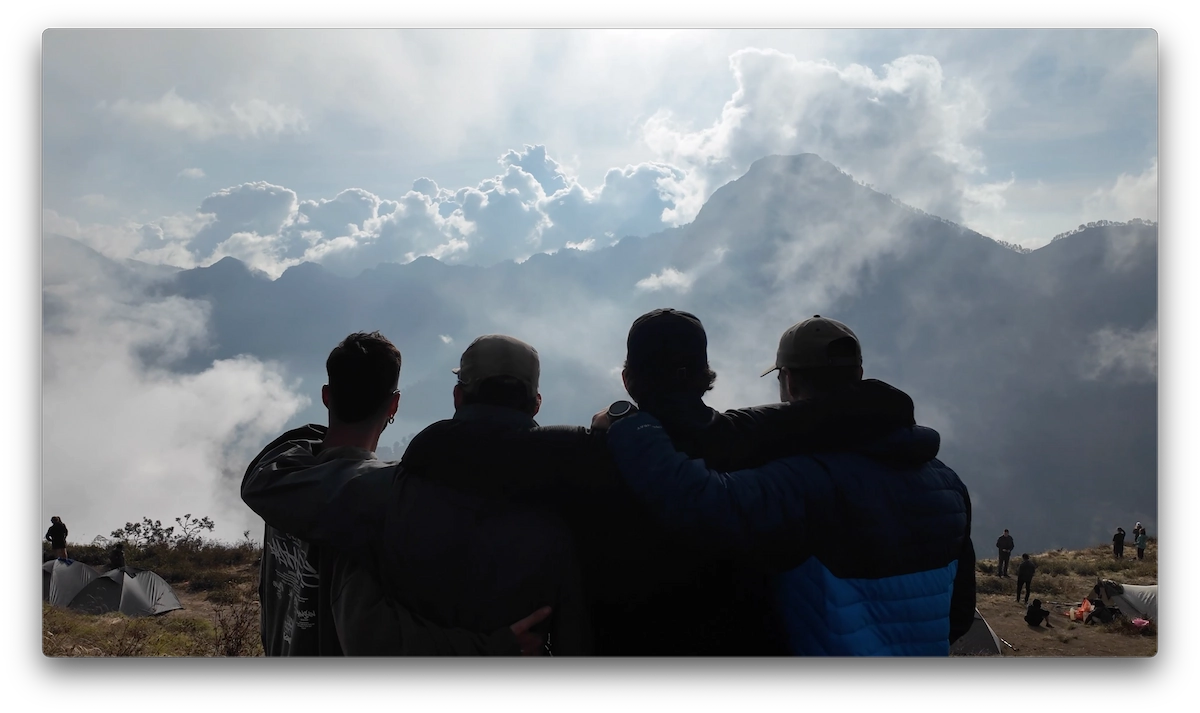 Los cuatro compañeros de Ruta Mochilera abrazados mirando el paisaje tras el Rinjani